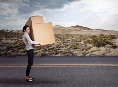 Young woman carrying heavy large box package 