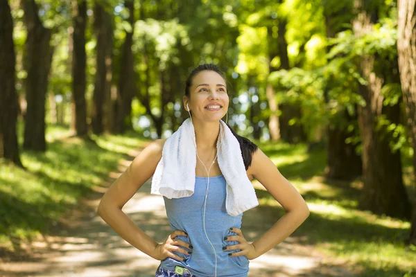 Smiling fit woman with white towel resting after sport exercises — 스톡 사진