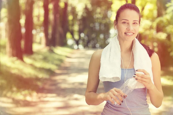 Lächelnde, fitte Frau mit weißem Handtuch, das sich nach sportlichen Übungen ausruht — Stockfoto