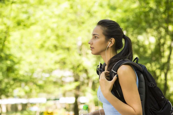 Female hiker with backpack walking on country forest trail — Stock Photo, Image