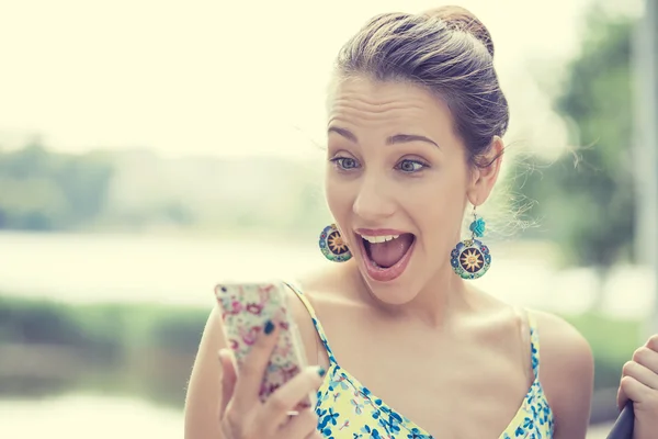 Surprised screaming young girl looking at mobile phone — Stock Photo, Image