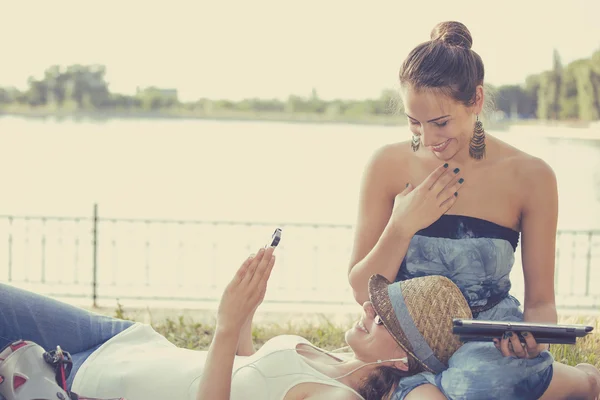 Happy women friends laughing browsing social media on mobile devices — 스톡 사진