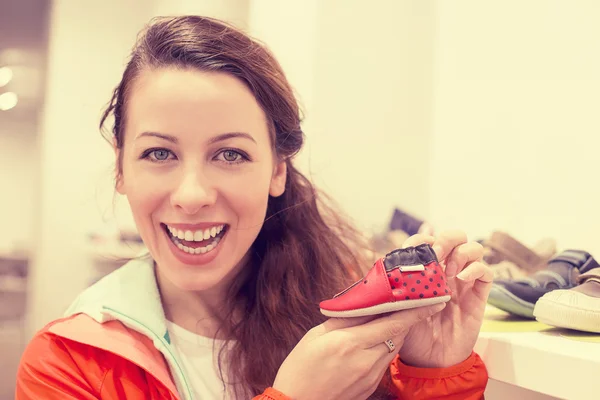 Feliz animado jovem mulher comprar sapatos para seu filho — Fotografia de Stock