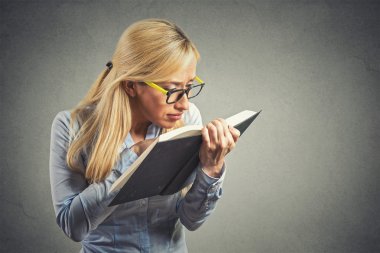 woman with eye glasses trying read book, has bad vision clipart