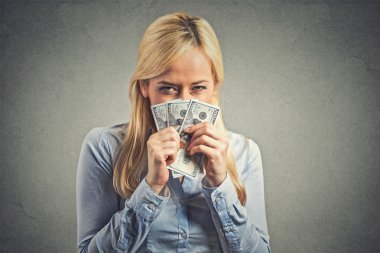 greedy young woman, holding tight dollar banknotes