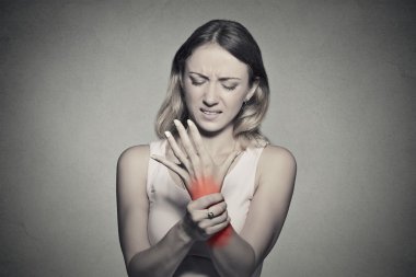 woman holding her painful wrist clipart