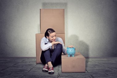 happy woman sitting on the floor with many boxes, moving out 