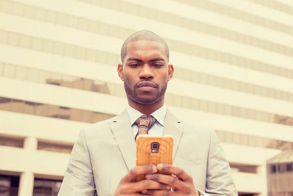 Handsome modern businessman walking in town with mobile phone — Zdjęcie stockowe