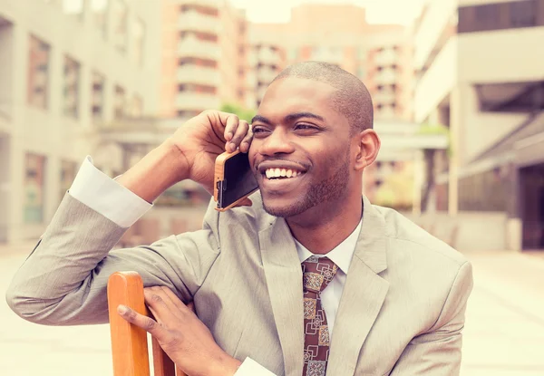 Handsome happy young businessman talking on mobile phone — Stock Photo, Image