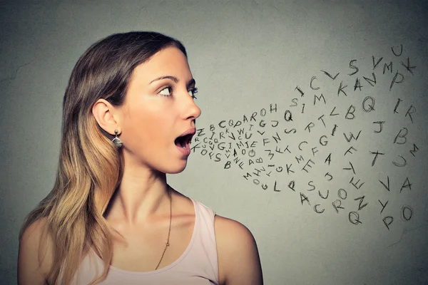 Kobieta rozmawia z liter alfabetu, wychodzi z jej ust — Zdjęcie stockowe