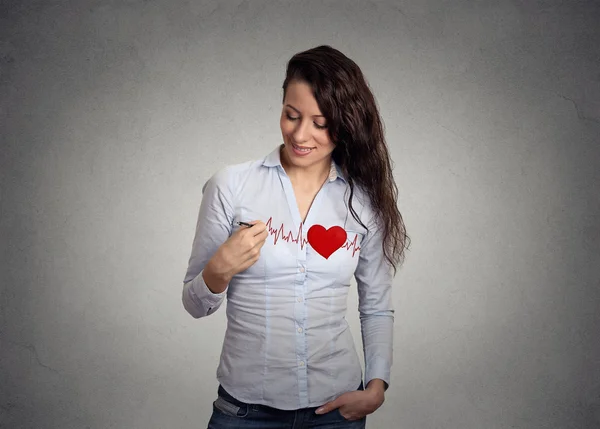 Batimento cardíaco. Jovem mulher desenhando um coração em sua camisa — Fotografia de Stock