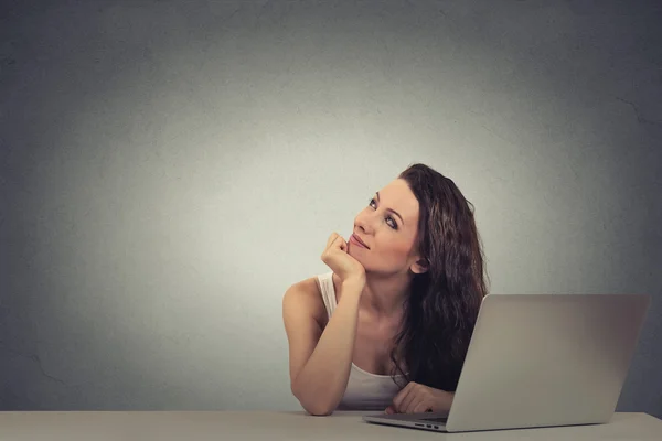 Nachdenkliche Frau, die an einem Laptop arbeitet und nachdenkt — Stockfoto