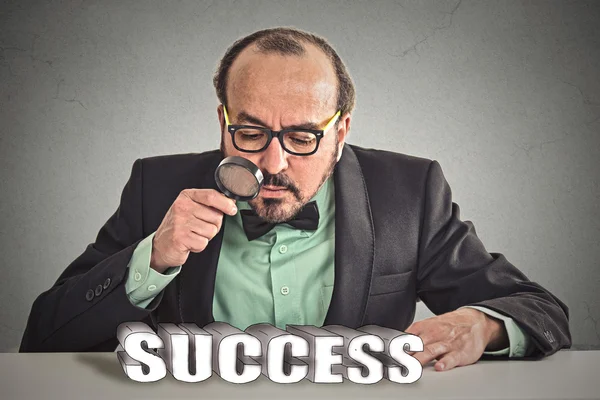 Business man boss looking through magnifying glass at success sign — Stockfoto