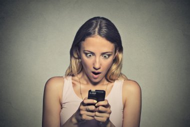 anxious young girl looking at phone seeing bad news