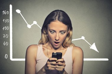 Shocked stunned young woman looking at her smart phone