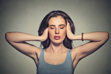 attractive casual woman covering with hands her ears 