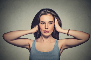 attractive casual woman covering with hands her ears