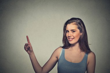 woman pointing with finger up to side at empty copy space