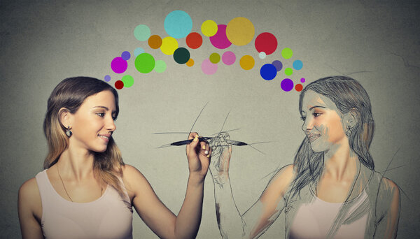  Привлекательная молодая женщина рисует картину, рисует себя
 