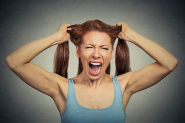 Portrait of a very angry woman screaming acting out 