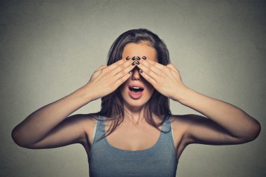 Beautiful young woman with her eyes covered by hands