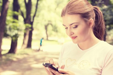 happy, cheerful, young woman excited by what she sees on cell phone texting 