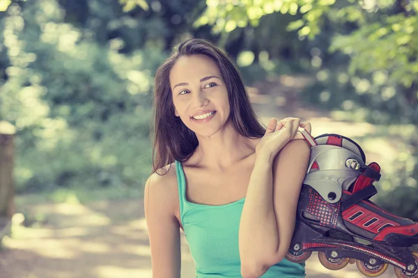 Retrato feliz joven mujer ir patinaje celebración en línea patines — Foto de Stock