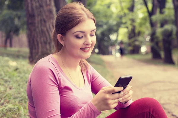 Feliz, alegre, jovem mulher animado pelo que ela vê no celular mensagens de texto — Fotografia de Stock