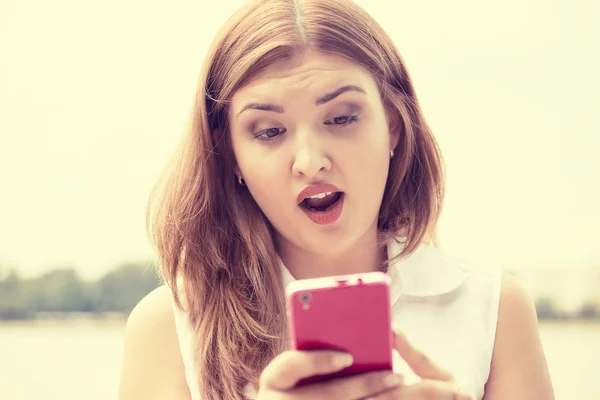 Woman looking at phone reading seeing bad news with disgusting emotion on face — Zdjęcie stockowe