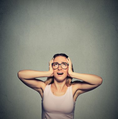 annoyed, unhappy, stressed woman covering her ears, looking up