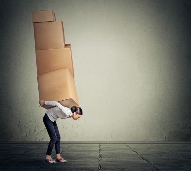 girl holding carrying several boxes on her back in equilibrium