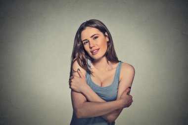 confident smiling woman holding hugging herself 
