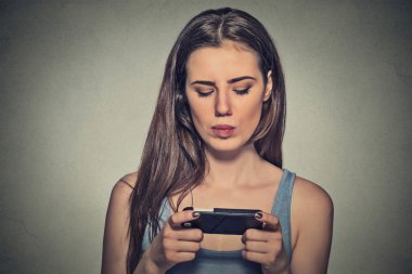 woman unhappy, annoyed by something, someone on her cell phone texting
