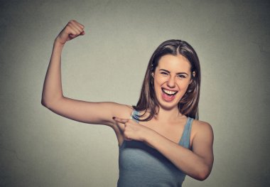 beautiful fit young healthy model woman flexing muscles showing her strength 