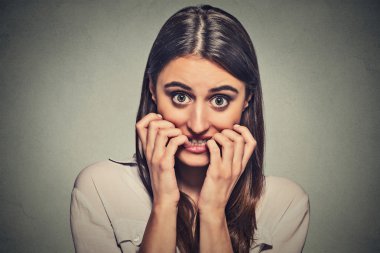 young anxious unsure hesitant nervous woman biting her fingernails