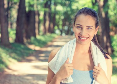 smiling fit woman with white towel resting after workout