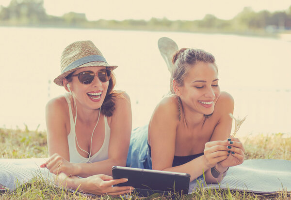 Two funny happy young women friends enjoying summer day outdoors 