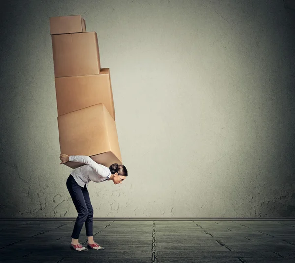 Girl holding carrying several boxes on her back in equilibrium — 图库照片