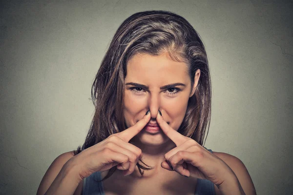 Woman pinches nose with fingers looks with disgust something stinks — Stok fotoğraf