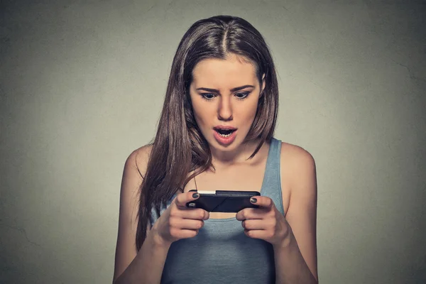 Anxious shocked young girl looking at phone seeing bad news or photos — Stock fotografie