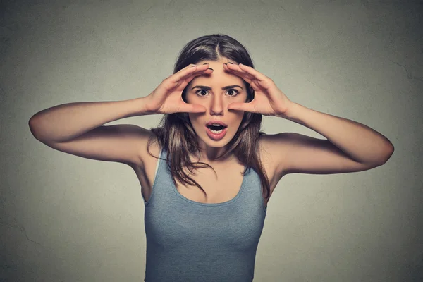 Woman, peeking through fingers like binoculars  surprised shocked — Stok fotoğraf