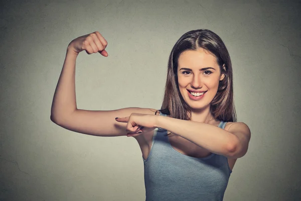 Beautiful fit young healthy model woman flexing muscles showing her strength — ストック写真