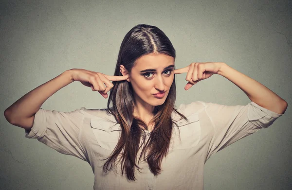 angry unhappy woman with closed ears looking at you 