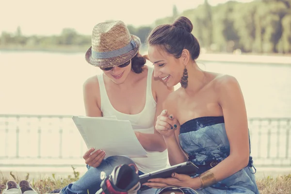 Dos amigos estudiantes mujeres al aire libre estudiando y luciendo felices —  Fotos de Stock