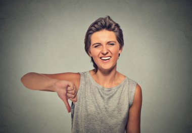 sarcastic young woman showing thumbs down sign hand gesture
