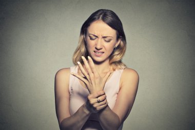 Young woman holding her painful wrist. Sprain pai