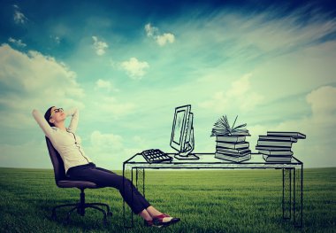 young businesswoman relaxing sitting in the office in the middle of a green meadow