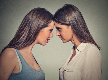 Side profile unhappy young female friends looking at each other clipart