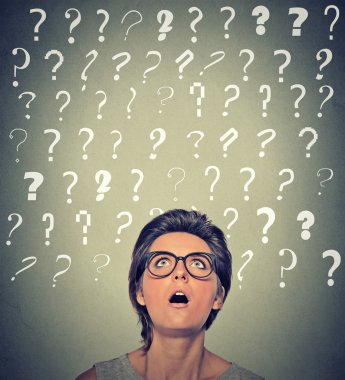 Thinking surprised woman with glasses looking up on many questions mark