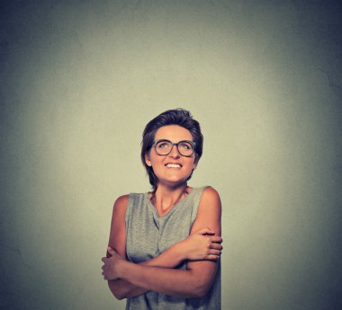 smiling woman with glasses holding hugging herself